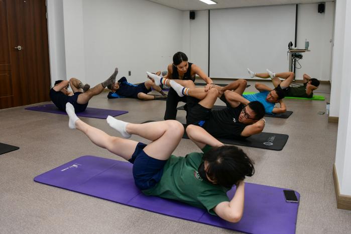 장병들이 전문 강사의 지도에 따라 스트레칭 자세를 취하고 있다.