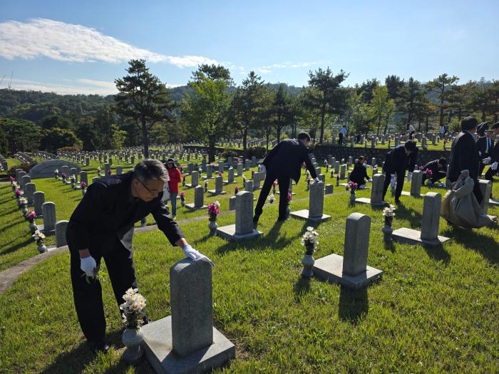 한국국방연구원(KIDA) 주요 보직자와 신입직원들이 22일 국립서울현충원에서 헌화·참배를 마친 뒤 묘역 정화 활동을 하고 있다. KIDA 제공