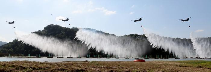 22일 충남 공주시 공산성 일대에서 열린 2025년 산불진화 통합훈련 중 육군항공사령부 시누크 헬기가 투입돼 공중 진화 시범을 보이고 있다. 연합뉴스