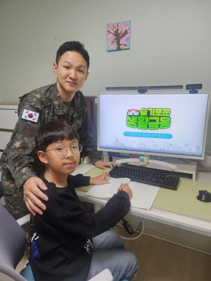 육군3군단 민대준 중령(진)과 아들 민동현 군이 금융스쿨 온라인 교육을 듣고 있다. 육군 제공