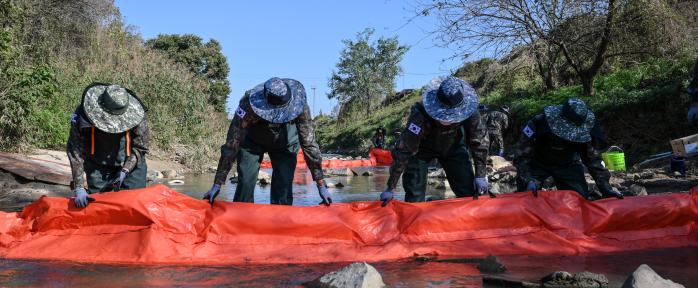 공군17전투비행단이 28일 기지 인근 미호강 일대에서 한국환경공단, 환경청 등 재난 대응 유관기관과 진행한 대량 유류 누출 대응훈련에서 장병들이 유류 확산 방지를 위한 오일펜스를 설치하고 있다. 사진 제공=김세환 상병