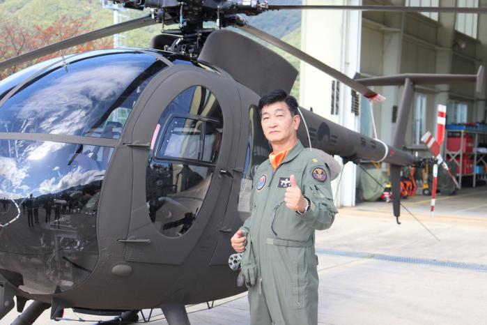 육군15항공단 문용남 준위가 고별비행 전 500MD 헬기 앞에서 포즈를 취하고 있다. 부대 제공