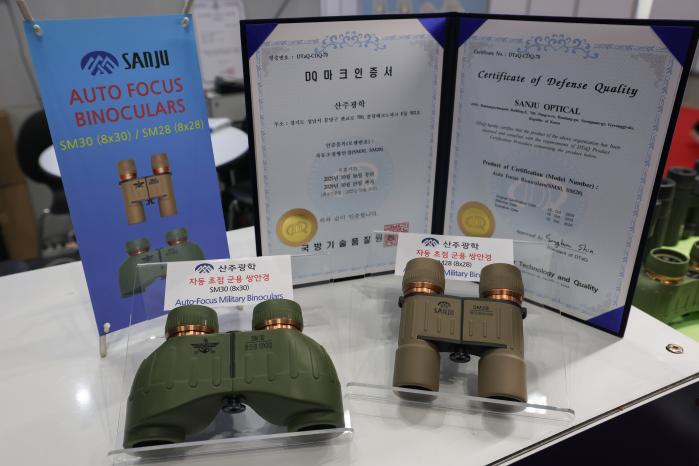 경기도 고양시 킨텍스 제2전시장에서 개최된 ‘서울 국제 항공우주 및 방위산업 전시회 2025(서울 ADEX 2025)’에서 DQ마크 인증을 받은 산주광학의 자동초점 군용 쌍안경 SM30, SM28 모델이 전시되어 있다.