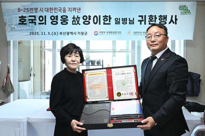 조해학(오른쪽) 국방부유해발굴감식단장 직무대리가 고 양이한 일병의 딸 양종금 여사에게 ‘호국의 얼 함’을 전달하고 있다. 부대 제공