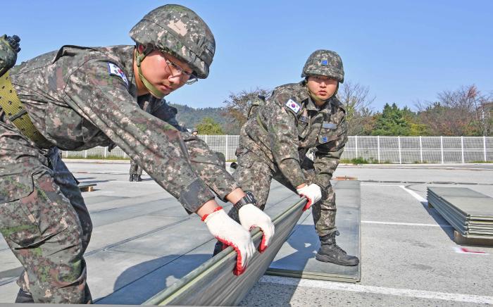 6일 해·공군 합동 활주로 피해복구 훈련에서 해군3함대와 공군1전투비행단 공병대원들이 피해복구 자재 AM-2 알루미늄 매트를 설치하고 있다. 부대 제공