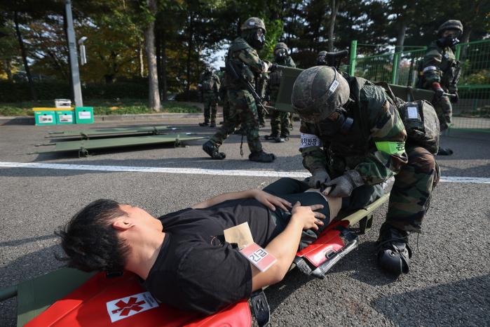 육군52보병사단 독수리여단 장병들이 지난 6일 서울 양천구 목동종합운동장에서 열린 대량사상자 관리훈련 중 들것에 실려 온 화생방 오염 환자를 응급처치하고 있다.