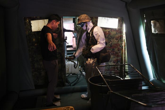 보행환자가 추가 제독을 위해 인체 샤워를 하고 있다.