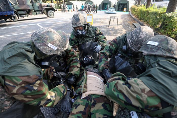 육군52보병사단 독수리여단 장병들이 지난 6일 서울 양천구 목동운동장에서 화랑훈련의 하나로 열린 대량사상자 관리훈련 중 들것에 실린 단순 오염자 피복을 제거하고 있다. 이윤청 기자