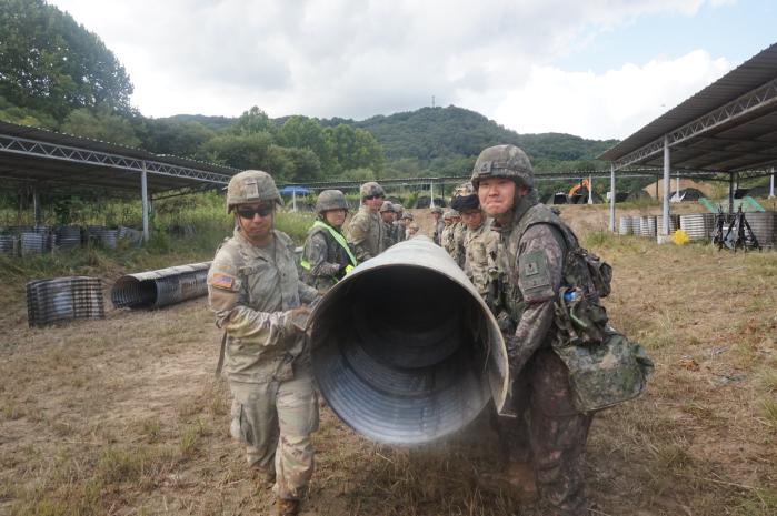 1115공병단 장병들이 한미 연합 공병훈련 중 철판관을 옮기고 있다.