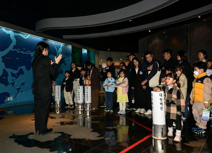 지난 8일 해군2함대 다문화가정 초청행사에 참가한 가족들이 부대 서해수호관에서 해설사의 설명을 듣고 있다. 부대 제공