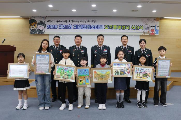 지난 7일 계룡시청에서 진행된 제21회 지상군페스티벌 호국문예행사 시상식에서 지상군페스티벌기획단 장병들이 주요 수상자들과 기념촬영을 하고 있다. 앞줄 왼쪽부터 대전시 자운초등학교 정주은, 계룡시 용남초등학교 이소율, 대구시 세천초등학교 김승호, 포항시 효자초등학교 김휘주, 계룡시 금암초등학교 박병준, 계룡시 용남초등학교 강유, 대구시 세천초등학교 김서하. 대전시 선유초등학교 최유빈. 육군 제공