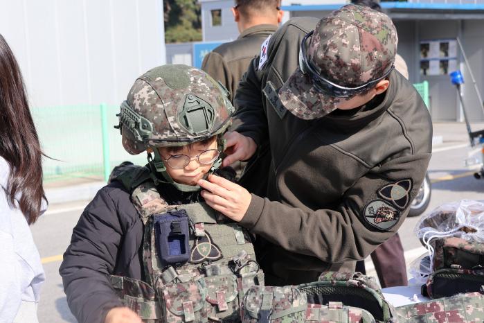 육군35보병사단 백마여단 장병이 서원초 학생의 방탄헬멧 착용을 돕고 있다. 부대 제공