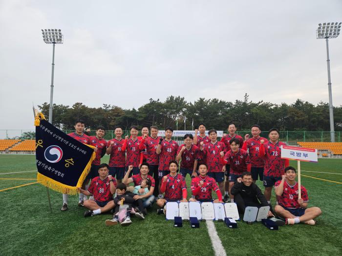 국무총리배 중앙부처 축구대회에서 2연패를 달성한 국방부 축구동호회 MND FC 선수들이 우승기를 들고 파이팅을 외치고 있다. 사진 제공=윤준용 육군원사