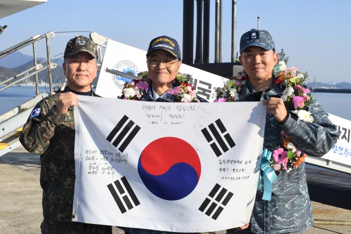 김태훈(소장) 잠수함사령관, 안병구 초대함장, 이제권 함장(왼쪽부터)이 태극기를 들고 기념사진을 찍고 있다.