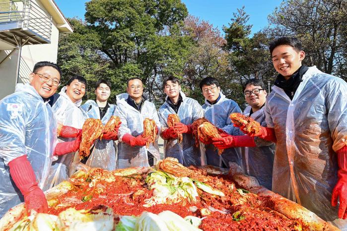 해군2함대 무기지원대대 장병들이 19일 평택시노인전문요양원에서 ‘사랑의 김장’ 봉사활동 중 자신들이 담근 김치를 들어 보이고 있다. 사진 제공=황정민 하사
