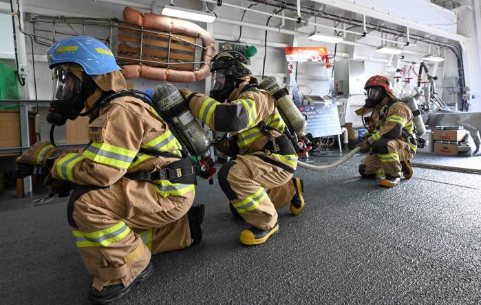 해군1함대 화생방지원대 소방소대와 동해소방서 대원들이 합동 화재 대응훈련에서 화재 진압을 위해 강원함 격납고 내부로 진입하고 있다. 부대 제공