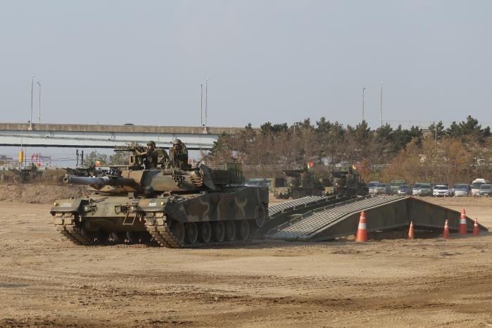 K1E1 전차가 교량을 통해 장애물 지대를 극복하고 있다.