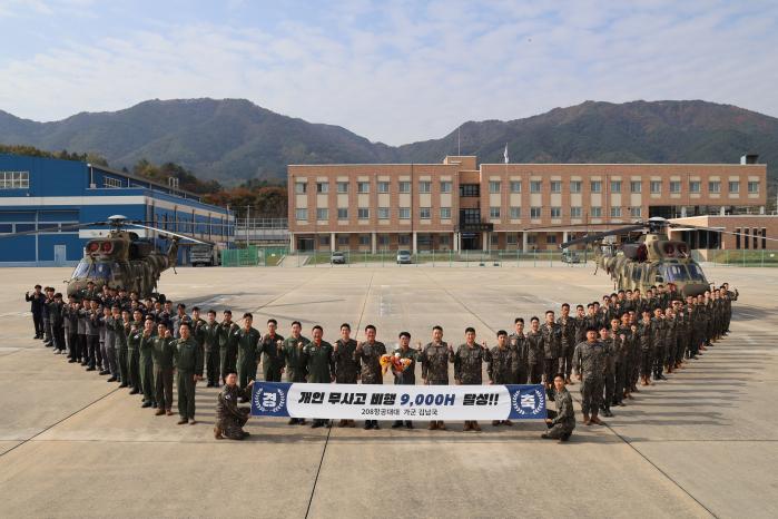 육군3군단 13항공단에서 시험비행 조종사로 임무 수행 중인 김남국 전문군무경력관의 무사고 비행 9000시간 달성을 축하하며 부대원들이 기념사진을 찍고 있다. 부대 제공