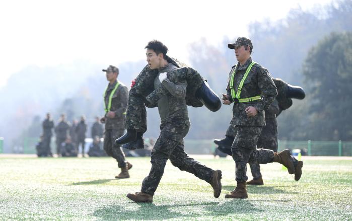 26일 육군52보병사단 잔디연병장에서 열린 전투임무위주 체력단련 경연대회에 참가한 장병들이 전장순환운동 종목을 수행하며 환자(70kg 더미) 어깨 메고 달리기를 하고 있다.