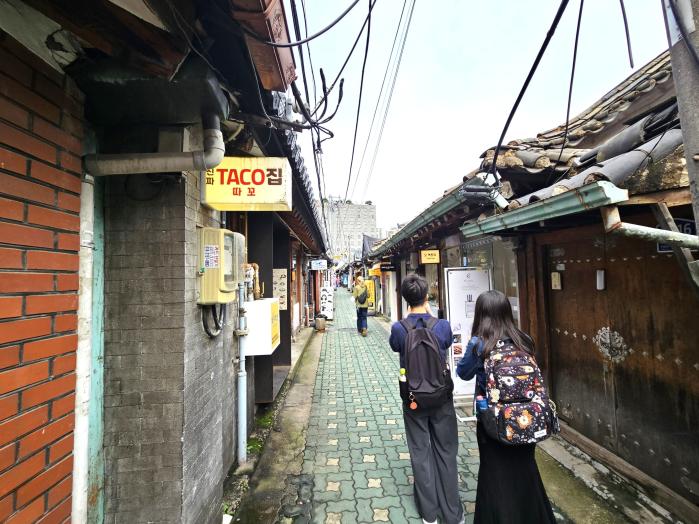 익선동 한옥 골목에서 사진을 찍고 있는 젊은이들.