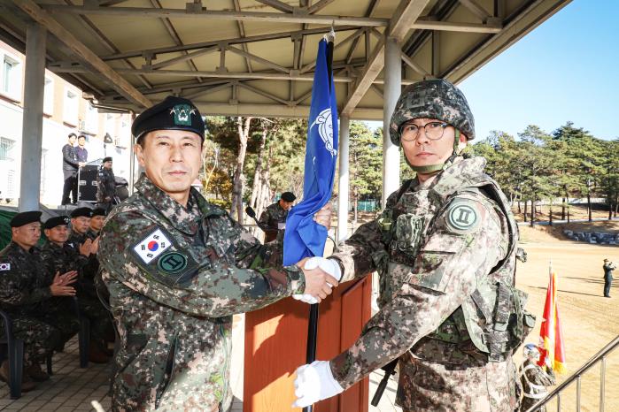 정유수(왼쪽) 육군2군단장이 1일 김경철 군단 군악대장에게 부대기를 수여하고 있다. 부대 제공