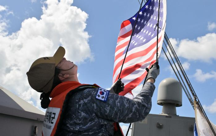 괌 아프라항에 입항한 마라도함 마스트에 성조기를 게양하는 모습.
