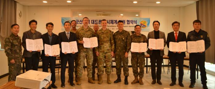 육군35보병사단 충무여단이 미8전투비행단 등과 개최한 ‘군산지역 대드론 감시체계 지원 협약식’ 참석자들이 협약서를 들어 보이고 있다. 부대 제공