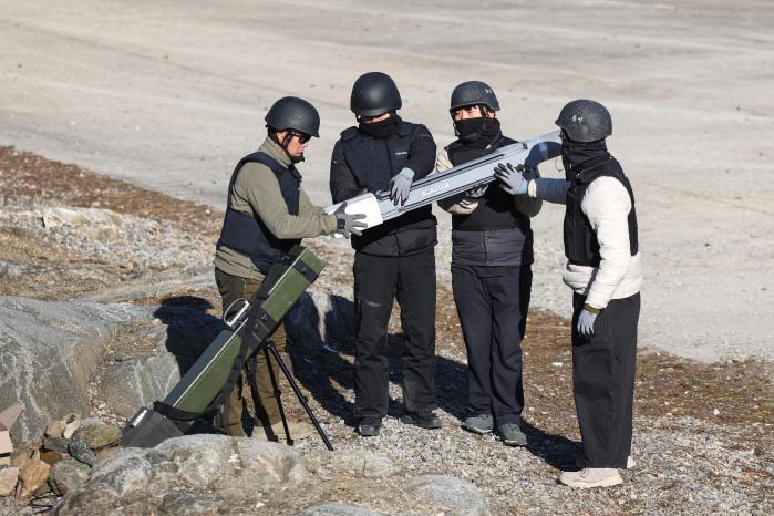 참가자들이 캐니스터에 직충돌드론을 넣고 있다.