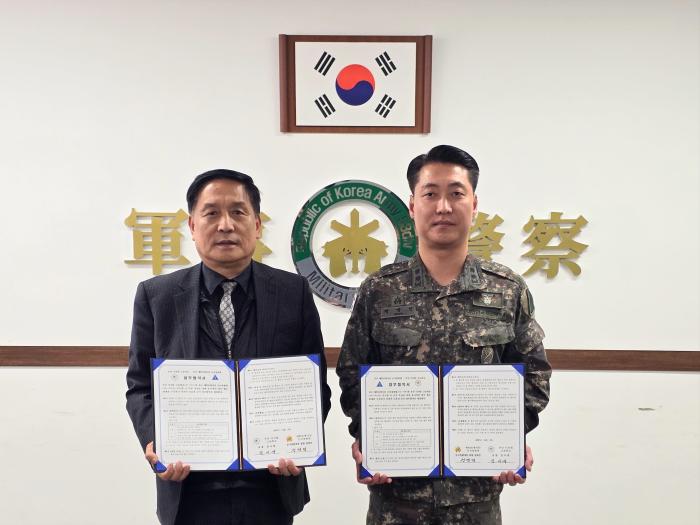 정영민(오른쪽) 육군53보병사단 군사경찰대장과 김시영 부산디지털고 교장이 지난 5일 업무협약 체결 후 협약서를 들어보이고 있다. 부대 제공