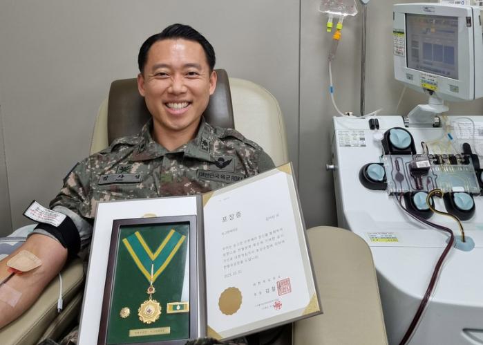 국방부 인사복지실 군무원정책과 김사성 육군소령이 최고명예대장을 받은 뒤 기념사진을 찍고 있다. 본인 제공