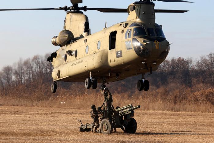 2신속대응사단 장병들이 105㎜ 견인포 인양을 위해 슬링 고리를 미군 시누크 헬기 하단 금속 고리와 결합하고 있다.