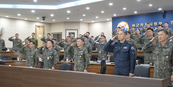 9일 해군작전사령부가 부산작전기지에서 개최한 2025년 후반기 교육훈련 분석평가회의에서 김경률(앞줄 가운데) 해군작전사령관을 비롯한 주요 지휘관 및 참모들이 국기에 대한 경례를 하고 있다. 부대 제공
