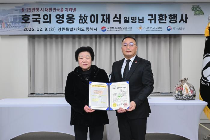 조해학(오른쪽) 국방부 유해발굴감식단장 직무대리가 9일 고 이재식 일병의 딸 이춘예 씨에게 전사자 신원확인 통지서를 전달하고 있다. 부대 제공