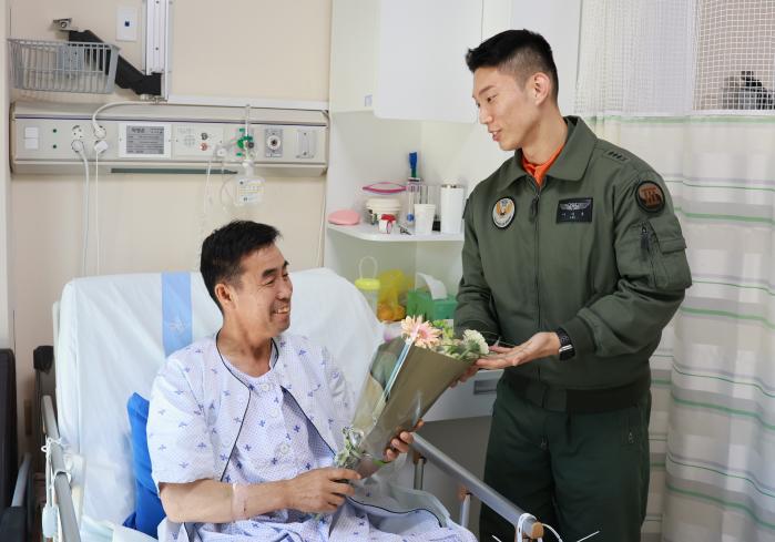 육군3군단 항공단 이지홍 대위가 국군수도병원을 찾아 당시 사고를 당한 박병춘 씨를 병문안하고 있다. 부대 제공