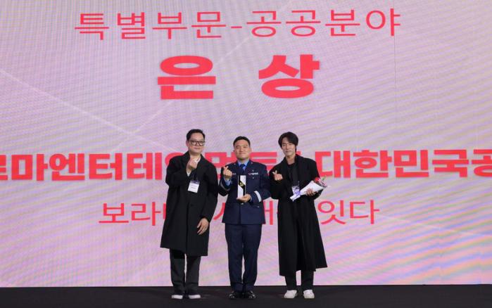 11일 열린 ‘2025 대한민국 디지털 광고대상 시상식’에서 김세현(가운데) 공군본부 미디어콘텐츠과장이 대표로 상을 받은 뒤 기념사진을 찍고 있다. 공군 제공