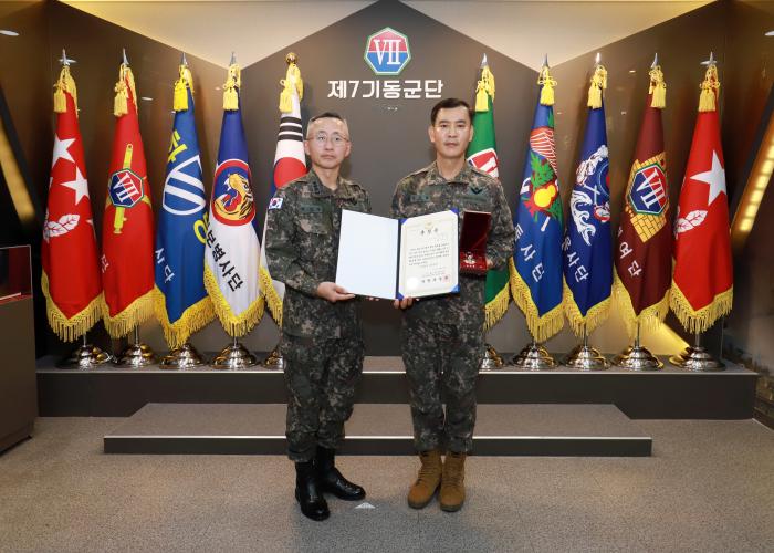 최성진(왼쪽) 육군7기동군단장이 11일 김준환 원사에게 종조부의 화랑무공훈장과 훈장증을 전수한 뒤 기념사진을 찍고 있다. 부대 제공