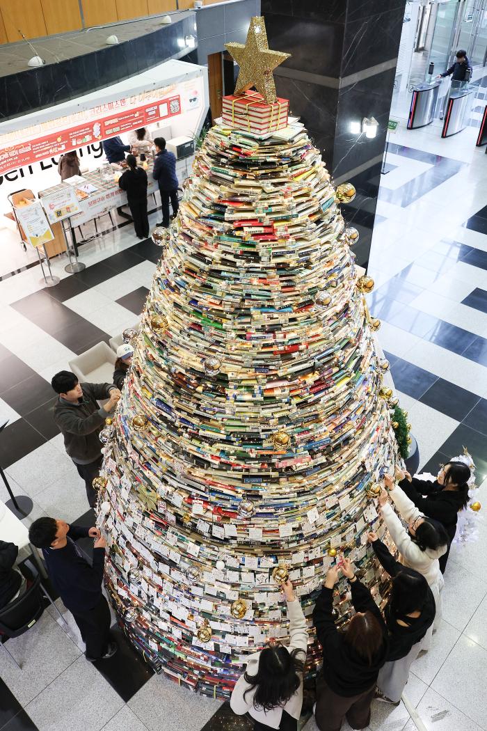16일 대구대 경산캠퍼스 창파도서관에서 재학생들이 크리스마스를 앞두고 설치된 북(Book) 트리에 소원지를 붙이고 있다. 북 트리는 크리스마스를 앞두고 도서관 활성화를 위해 조성됐으며, 폐기 예정인 도서 4000권을 활용해 높이 5m, 폭 3m 규모로 설치됐다. 연합뉴스