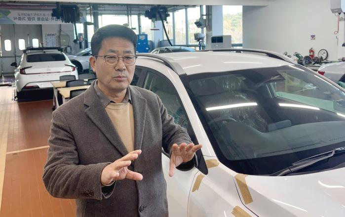 경기과학기술대 학군인력양성센터 이정휘 교수가 교내 자동차 종합실습실에서 ‘e-MU’ 미래전기자동차과 교육 과정을 설명하고 있다.