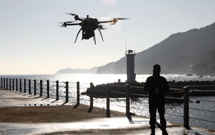 육군23경비여단 청룡대대 드론정찰반장이 18일 강원 강릉시 안인항 인근에서 경계용 드론에 부착한 자동팽창형 튜브 작동 여부를 점검하고 있다.