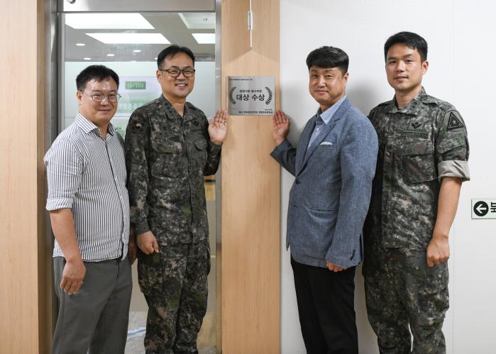 최성오(오른쪽 둘째) 생명존중문화과장을 비롯한 전투준비안전단 관계자들이 2025년 생명사랑대상 우수기관 수상 현판 앞에서 기념 사진을 찍고 있다.