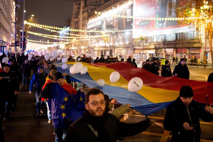 21일(현지시간) 루마니아 부쿠레슈티에서 루마니아 혁명 36주년을 앞두고 ‘영웅들의 행진’ 행사가 열려 시민들이 대형 국기를 들고 행진하고 있다. 루마니아는 1989년 12월 25일 공산 독재자 니콜라에 차우셰스쿠를 처형하고 공산 체제를 무너뜨린 것을 ‘혁명의 날’로 기념한다 AP·연합뉴스