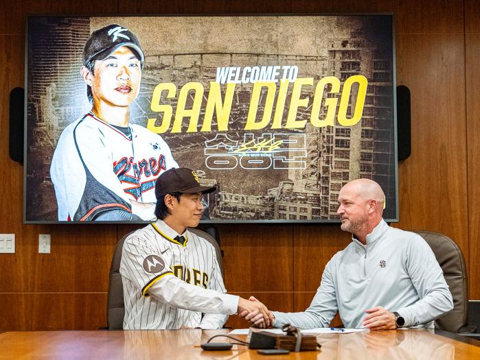 송성문(왼쪽)이 22일(한국시간) 미국 캘리포니아주 샌디에이고의 펫코파크에서 미국프로야구 메이저리그 샌디에이고 파드리스 입단 계약서에 사인한 뒤 구단 관계자와 악수하고 있다. 키움 히어로즈 제공