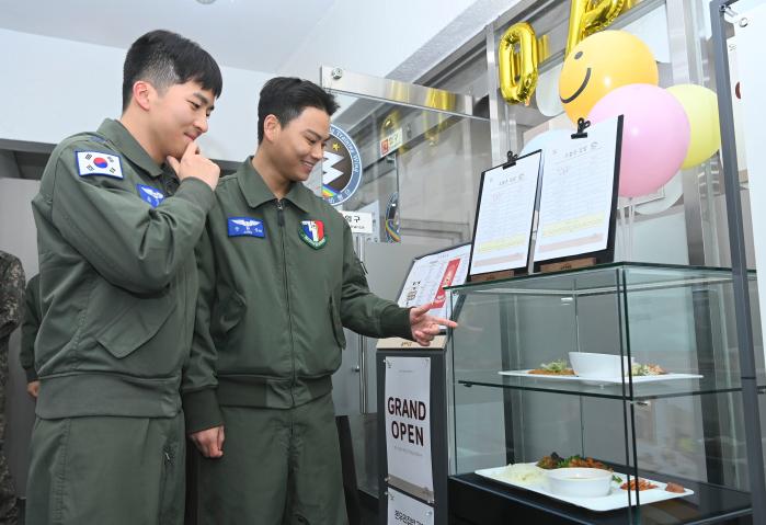 23일 공군3훈련비행단(3훈비) 학생조종사들이 간부식당 메뉴를 보고 어떤 음식을 먹을지 고민하고 있다. 3훈비는 이날 공군에서는 처음으로 간부식당을 민간위탁으로 전환했다. 부대 제공