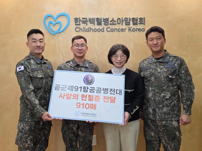 공군91항공공병전대 육근섭(왼쪽 둘째) 주임원사와 부대원들이 허인영(오른쪽 둘째) 한국백혈병소아암협회 사무총장에게 헌혈증 910장을 전달한 후 기념촬영하고 있다. 공군 제공