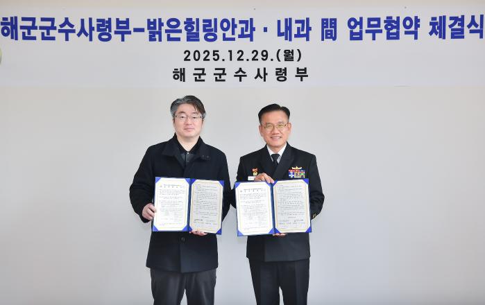 29일 진해 공관에서 진행된 업무협약식에서 안상민(오른쪽) 해군군수사령관과 이창민 밝은힐링안과·내과 대표원장이 협약서를 들어 보이고 있다. 사진 제공=최혜진 하사