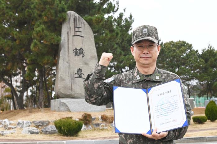 장애인 이웃들을 위한 봉사 공로를 인정받아 자원봉사자상을 받은 해군3함대 3훈련대대 손상통제 관찰관 안현재 원사가 파이팅을 외치고 있다. 부대 제공