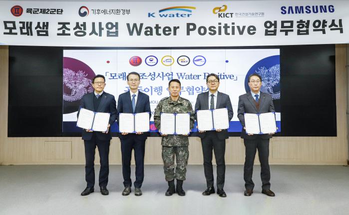 14일 육군2군단에서 열린 모래샘 조성사업 업무협약식에서 정유수(가운데) 군단장을 비롯한 민·관·군 관계관이 기념촬영을 하고 있다. 사진 제공=이문희 군무주무관