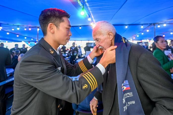 순항훈련 중 군사외교의 하나로 외국인 참전용사에게 머플러를 걸어주는 모습.