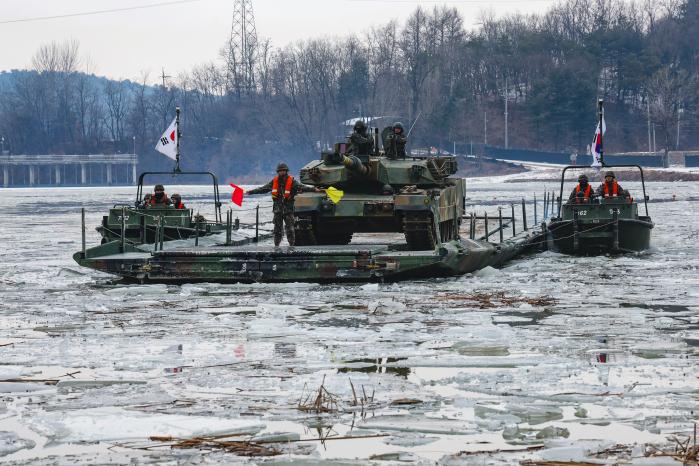 K1A2 전차가 교량가설단정 지원 속에 문교도하를 하고 있다.