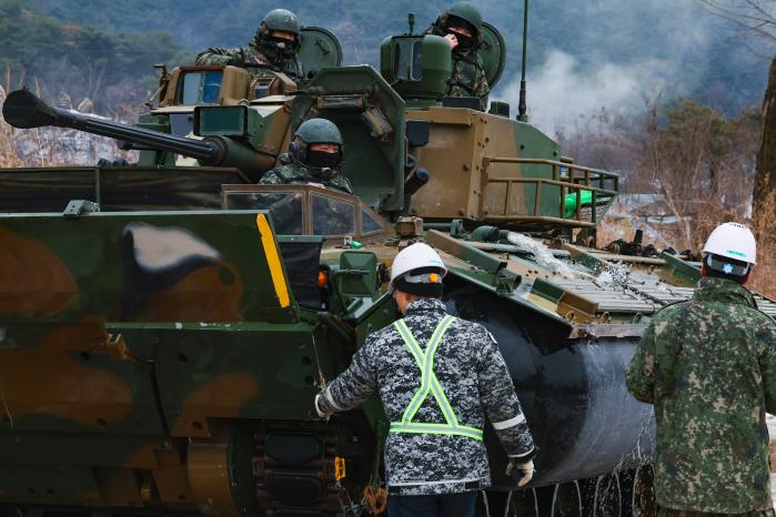 현장정비반이 도하를 마친 K21 보병전투장갑차를 점검하고 있다.